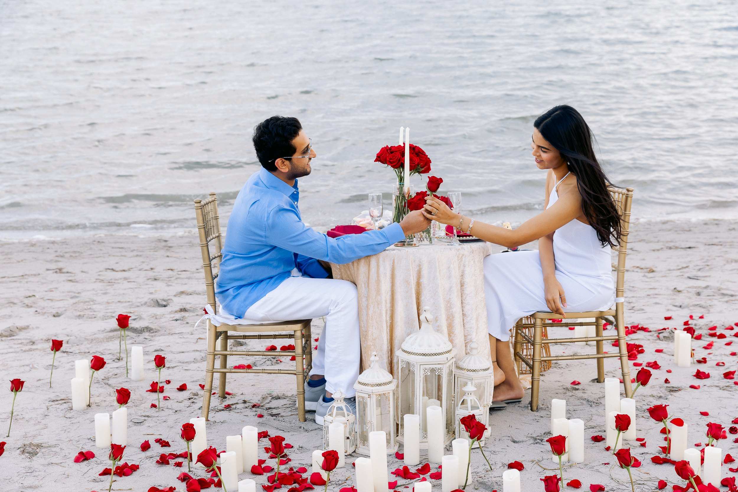 Couple at a candlelit dinner table on the beach