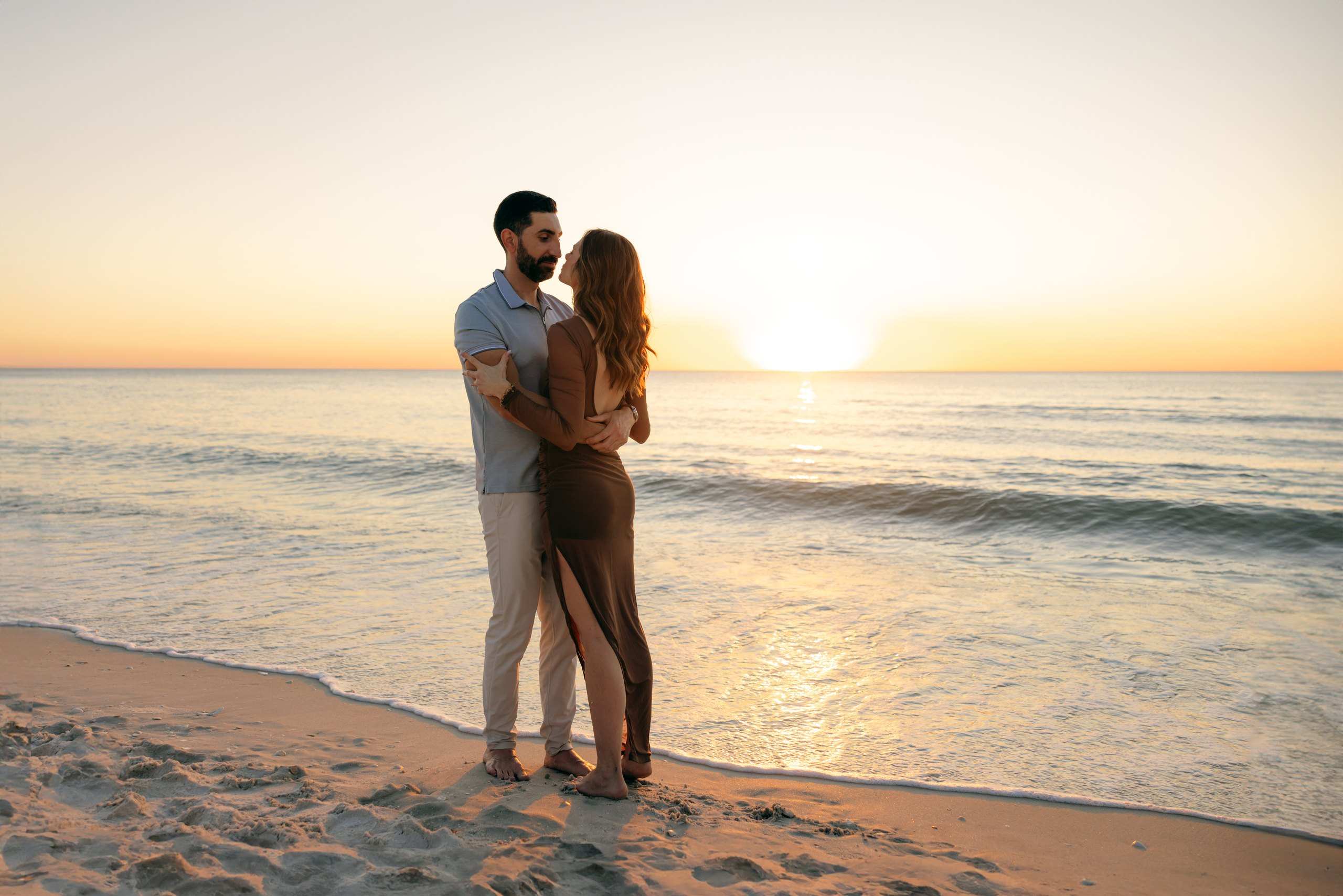 Engaged couple on the beach at sunset