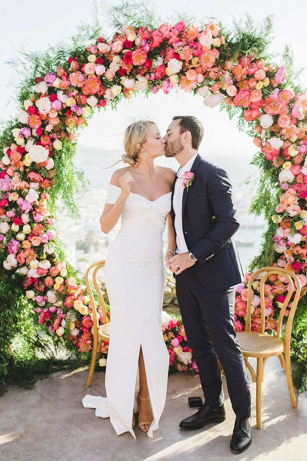 Couple in front of a round floral arch